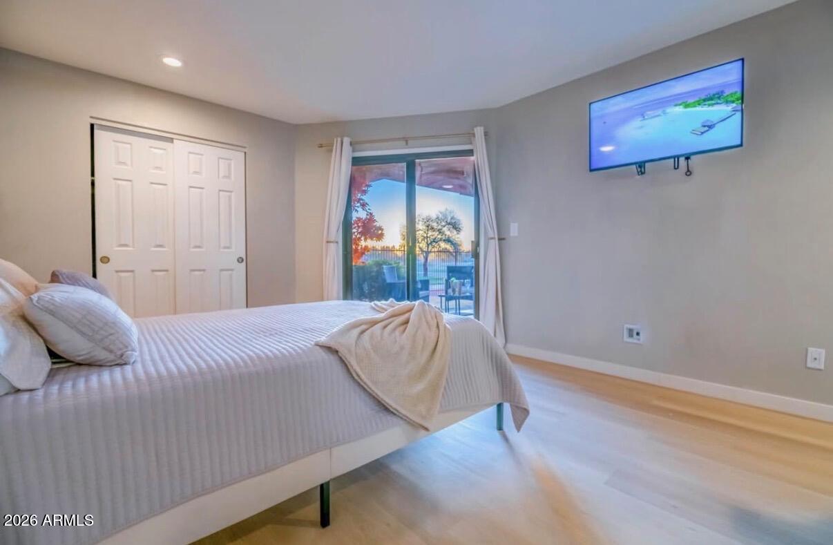 4303 East Cactus Road, Unit 128 Phoenix, AZ 85032 - Photo 25 of 39 a bedroom with a bed and wooden floor