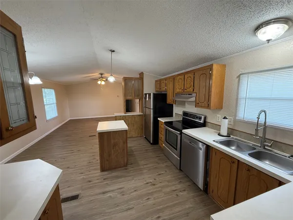 a kitchen with a sink cabinets and wooden floor