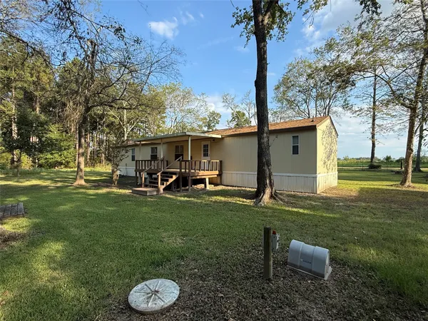 a view of a chair and table in backyard of the house