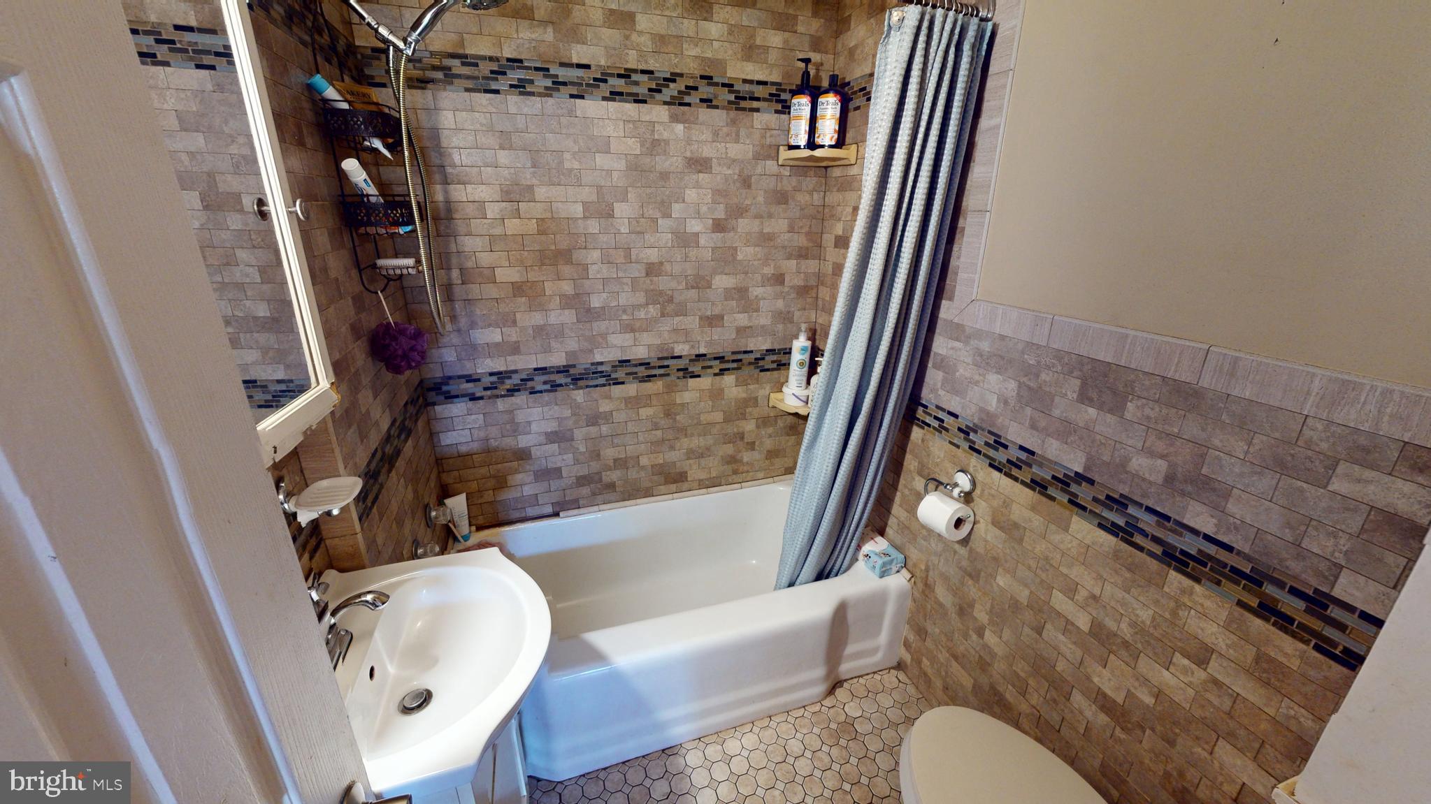 1401 Filbert Street Glassboro, NJ 08028 - Photo 15 of 18 a bathroom with a granite countertop bathtub shower and toilet