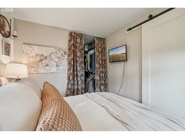 a bedroom with a bed and a flat screen tv