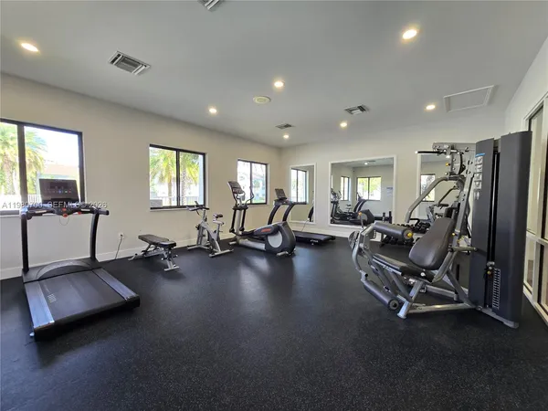 a living room with furniture gym equipment and a large window