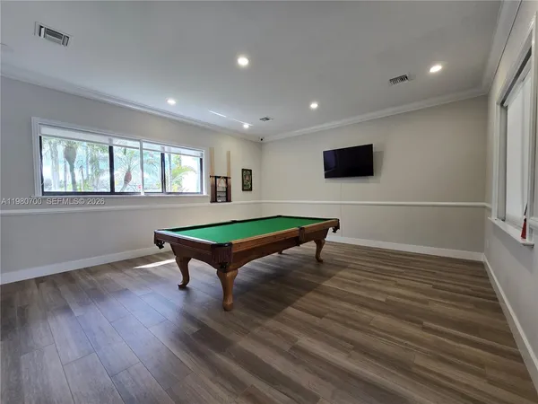 a living room with furniture a flat screen tv and a wooden floor