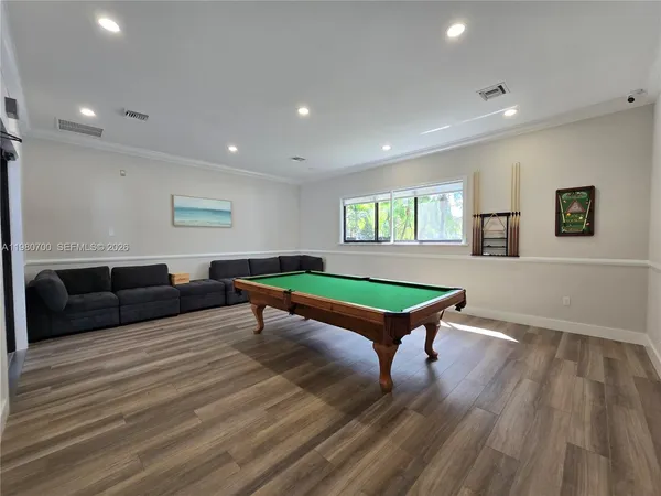a room with furniture pool table and windows