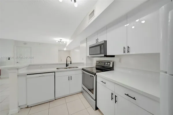 a kitchen with white cabinets appliances and sink
