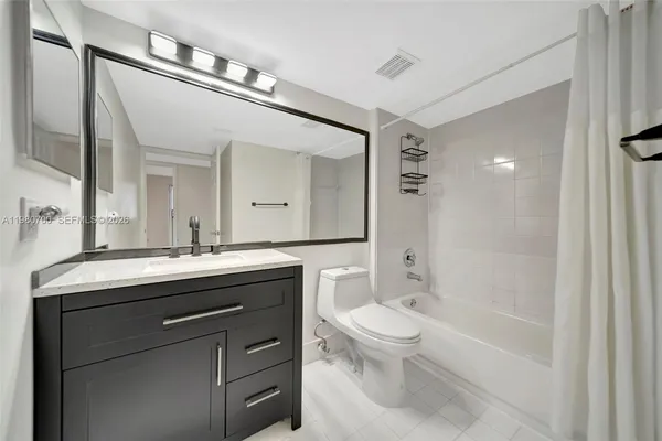 a spacious bathroom with a granite countertop toilet a sink and a mirror