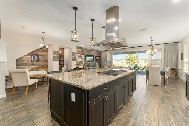 a kitchen with stainless steel appliances granite countertop a sink a stove and a wooden floors