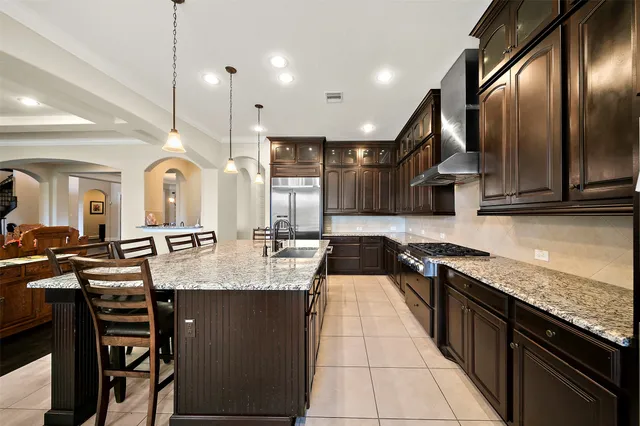 an open kitchen with granite countertop a stove a sink dishwasher and cabinets with wooden floor