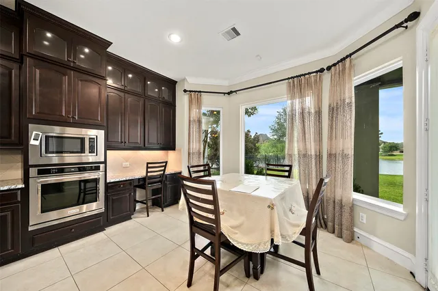 a kitchen with a table chairs refrigerator and cabinets