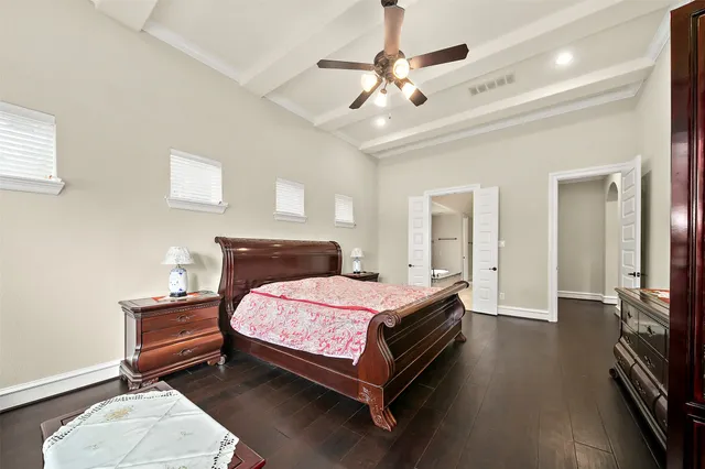 a bedroom with a bed and a flat tv screen on dresser