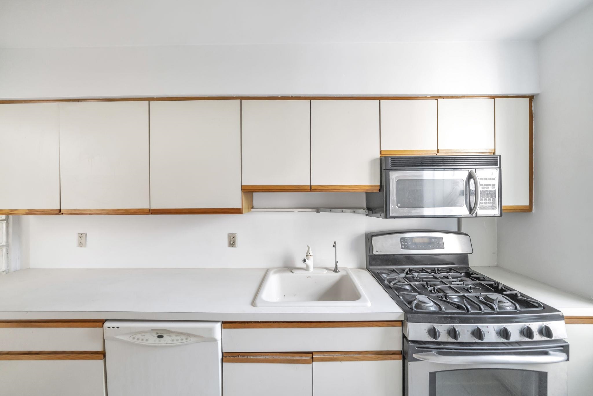 8450 Boulevard East, Unit 4F North Bergen, NJ 07047 - Photo 10 of 22 a kitchen with a sink a stove cabinets and a window