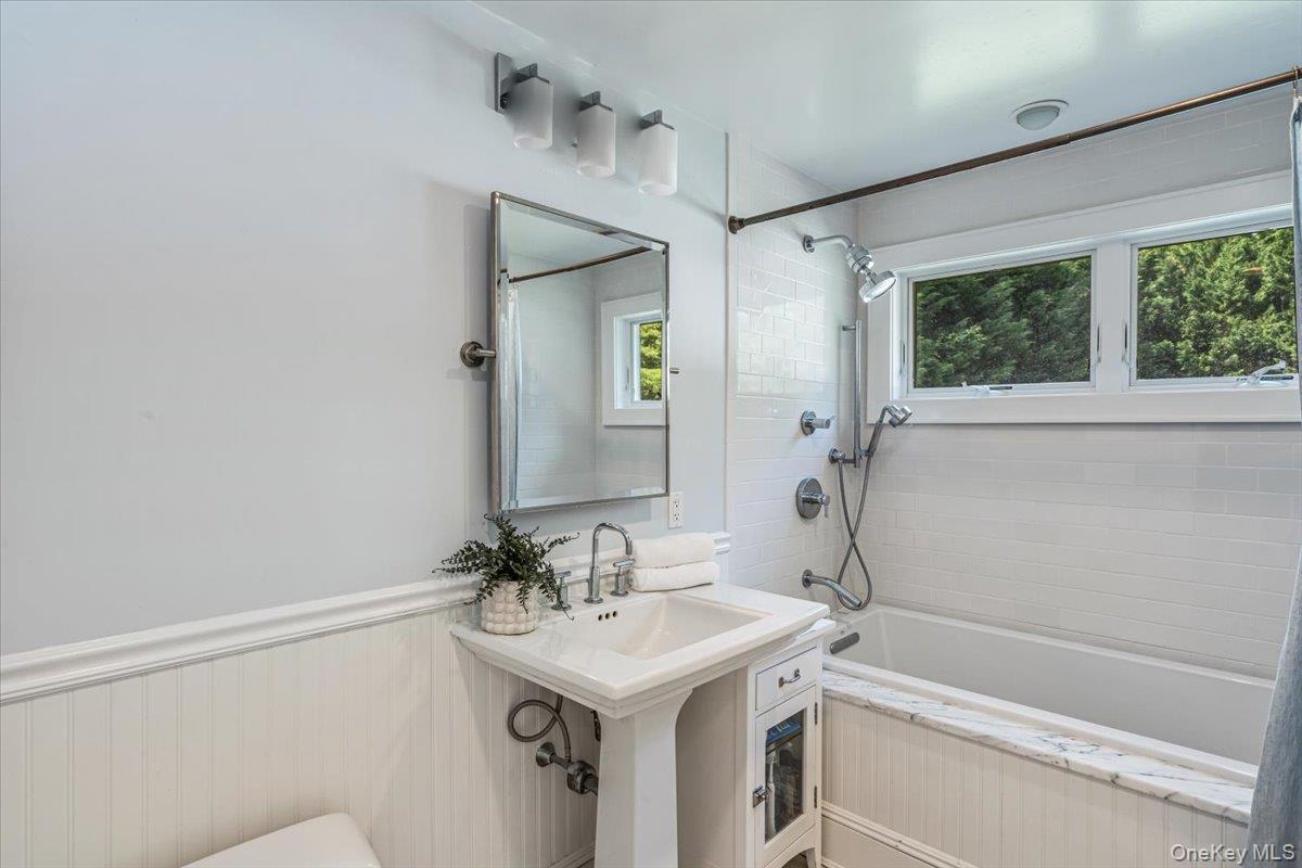 130 Sands Point Road Sands Point, NY 11050 - Photo 15 of 26 Bathroom featuring bathing tub / shower combination, a sink, and toilet