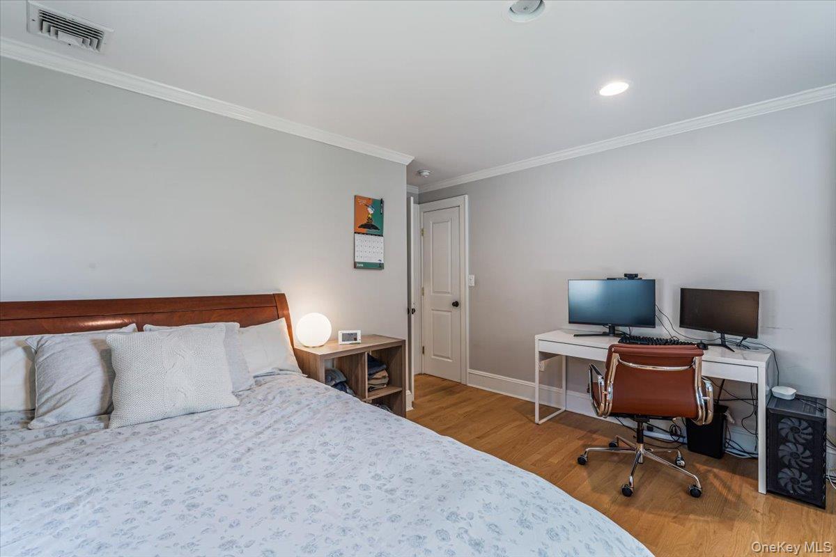 130 Sands Point Road Sands Point, NY 11050 - Photo 17 of 26 Bedroom featuring wood finished floors, ornamental molding, baseboards, a desk, and recessed lighting