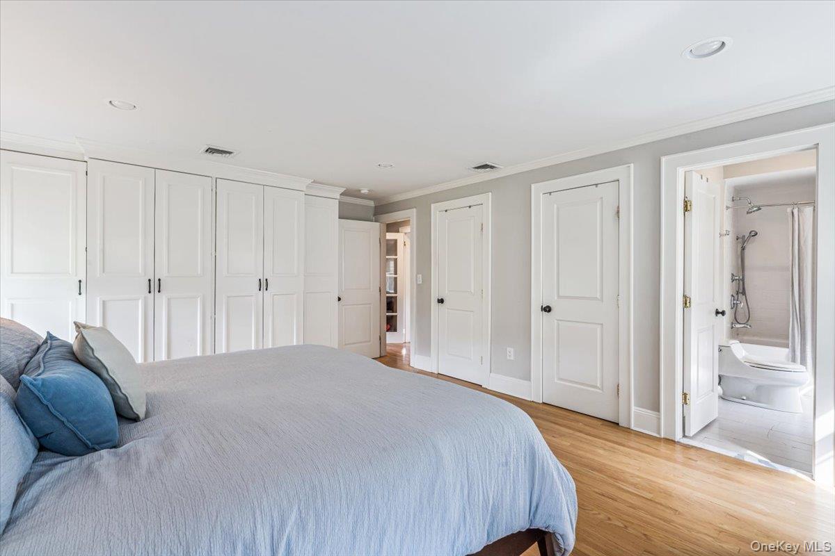 130 Sands Point Road Sands Point, NY 11050 - Photo 20 of 26 Bedroom with multiple closets, crown molding, light wood finished floors, baseboards, and recessed lighting