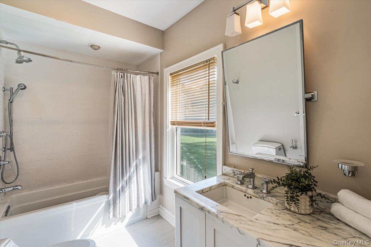 130 Sands Point Road Sands Point, NY 11050 - Photo 21 of 26 Bathroom with shower / bath combo with shower curtain, vanity, and tile patterned floors
