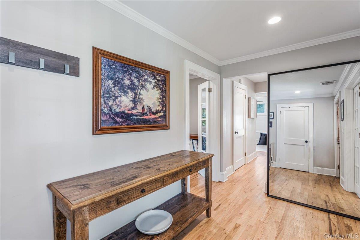 130 Sands Point Road Sands Point, NY 11050 - Photo 4 of 26 Hallway with light wood finished floors, baseboards, crown molding, and recessed lighting