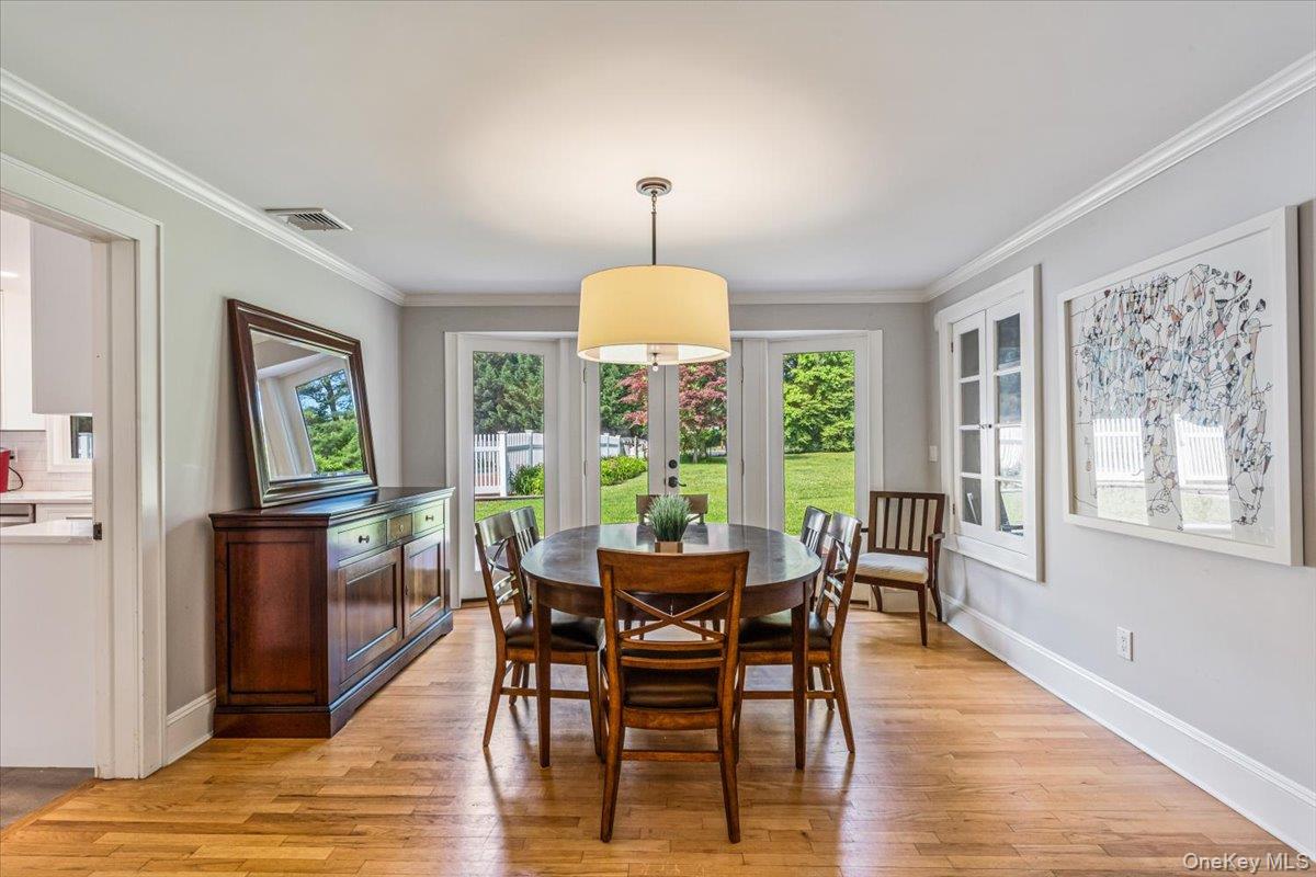 130 Sands Point Road Sands Point, NY 11050 - Photo 10 of 26 Dining room featuring plenty of natural light, light wood-style flooring, ornamental molding, baseboards, and french doors