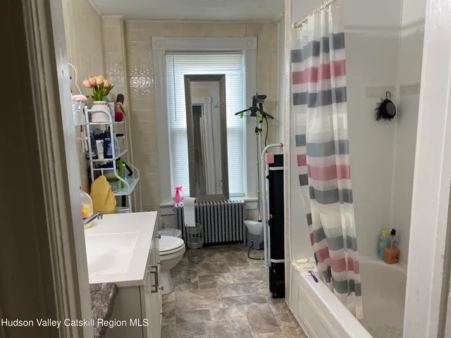 a bathroom with a bathtub shower and a sink