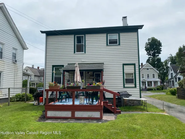 a front view of a house with porch and garden