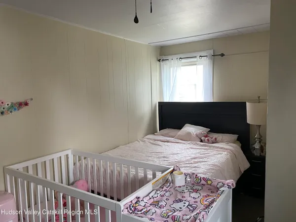 a bed sitting in a bedroom next to a window