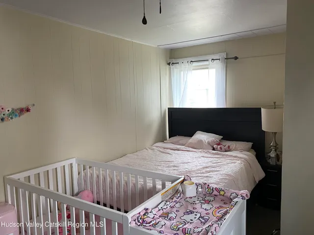 a bed sitting in a bedroom next to a window