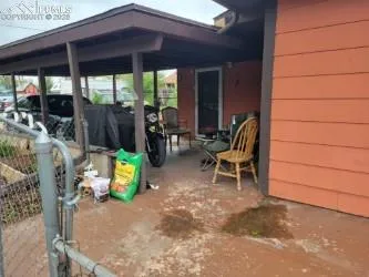 a view of a patio with table and chairs under an umbrella