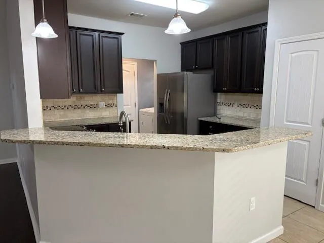 a kitchen with stainless steel appliances granite countertop a refrigerator and a sink