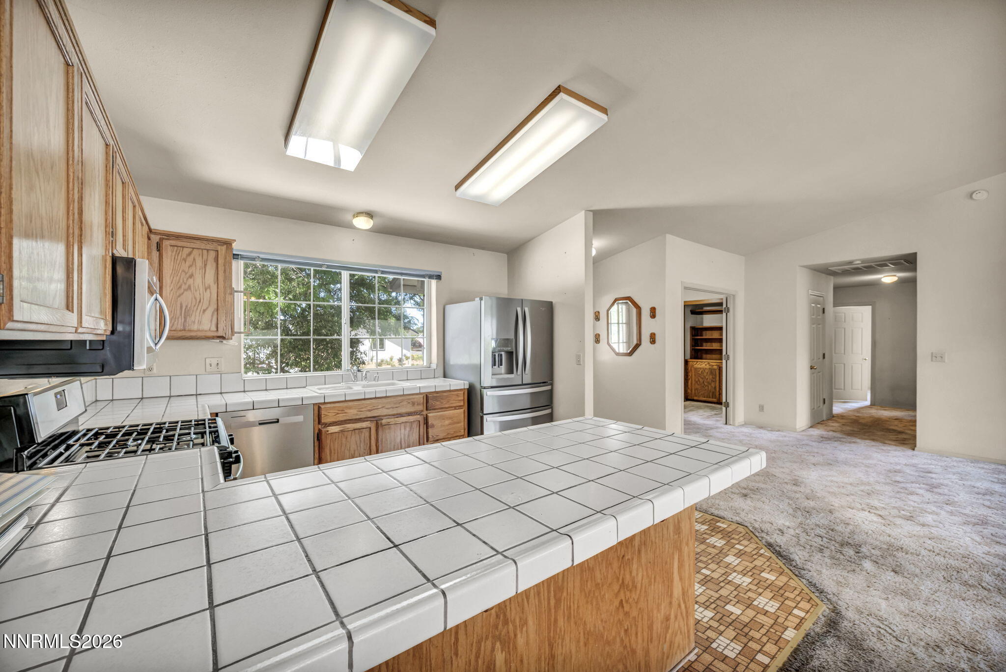 692 Lassen Way Gardnerville, NV 89460 - Photo 9 of 34 a large kitchen with granite countertop a stove a sink dishwasher and a refrigerator with wooden floor