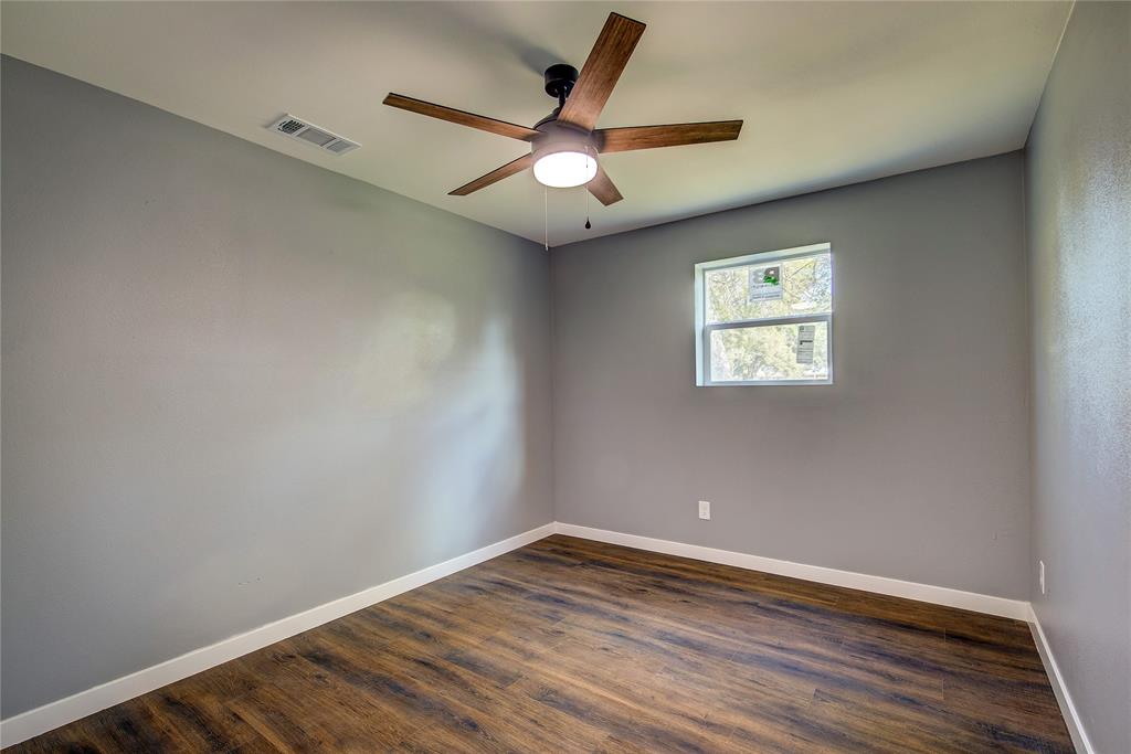520 North 1st Street Point, TX 75472 - Photo 16 of 34 an empty room with wooden floor and windows
