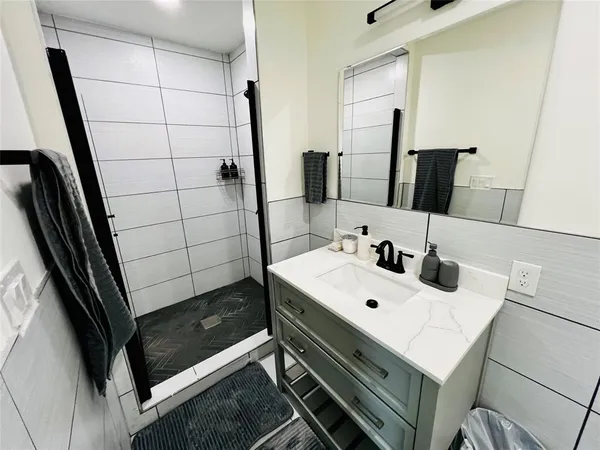 a bathroom with a sink a mirror and shower