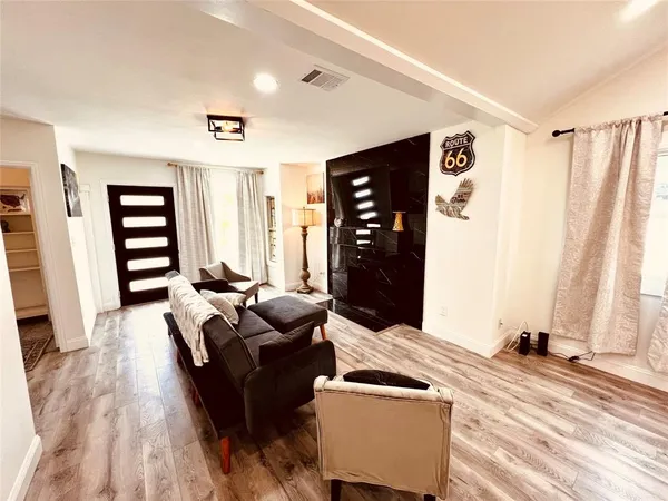 a living room with furniture and a wooden floor