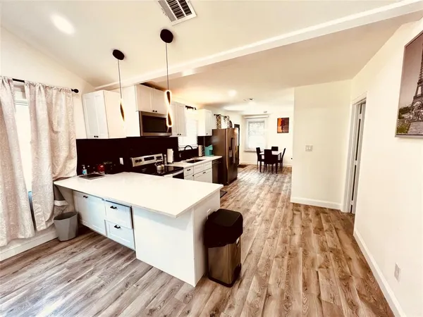 a kitchen view with wooden floor and white appliances