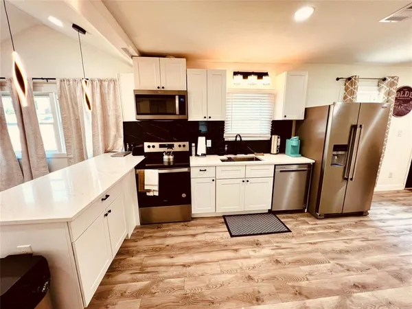 a kitchen with stainless steel appliances a refrigerator sink and cabinets