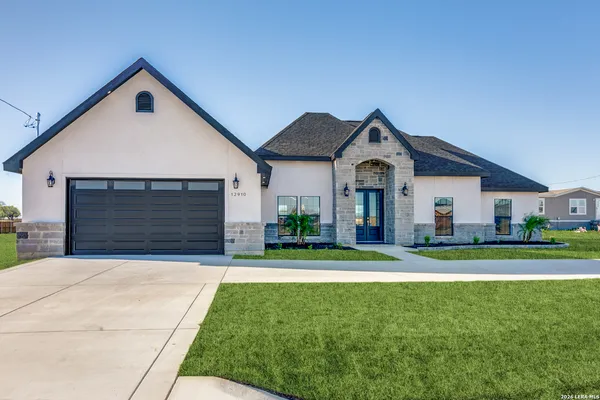 a front view of a house with a yard and garage