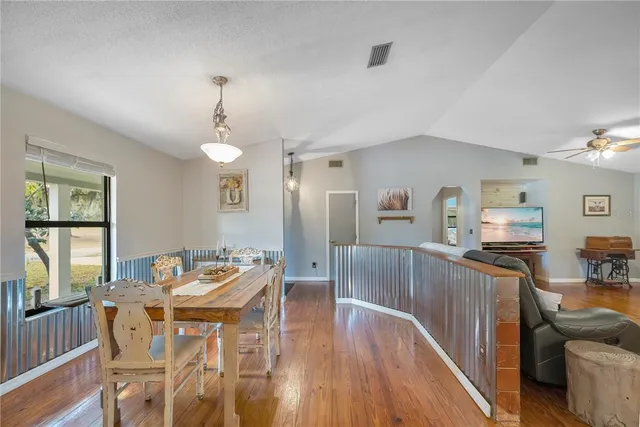 a living room with furniture chandelier and a wooden floor