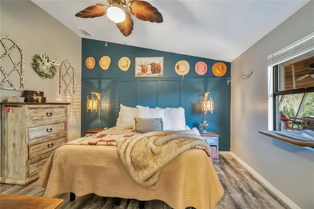 a bedroom with furniture and a chandelier fan