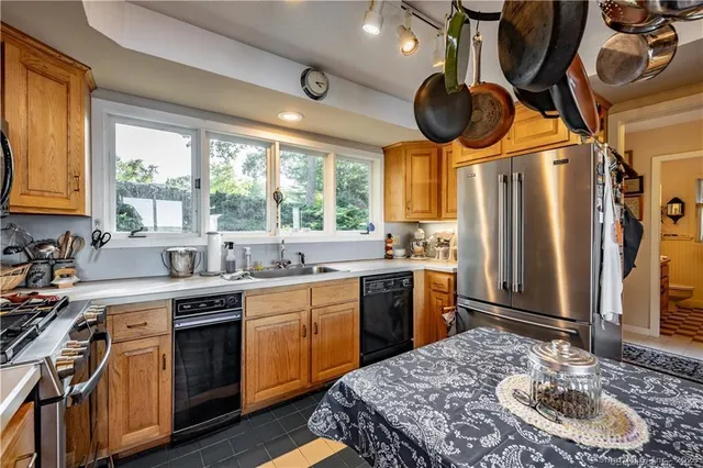 a kitchen with a sink appliances cabinets and a large window