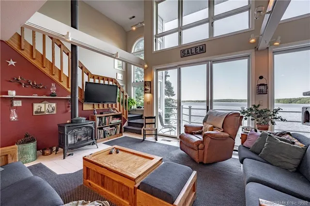 a living room with furniture a floor to ceiling window and a flat screen tv