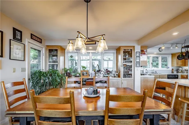 a dining room with furniture a chandelier and wooden floor