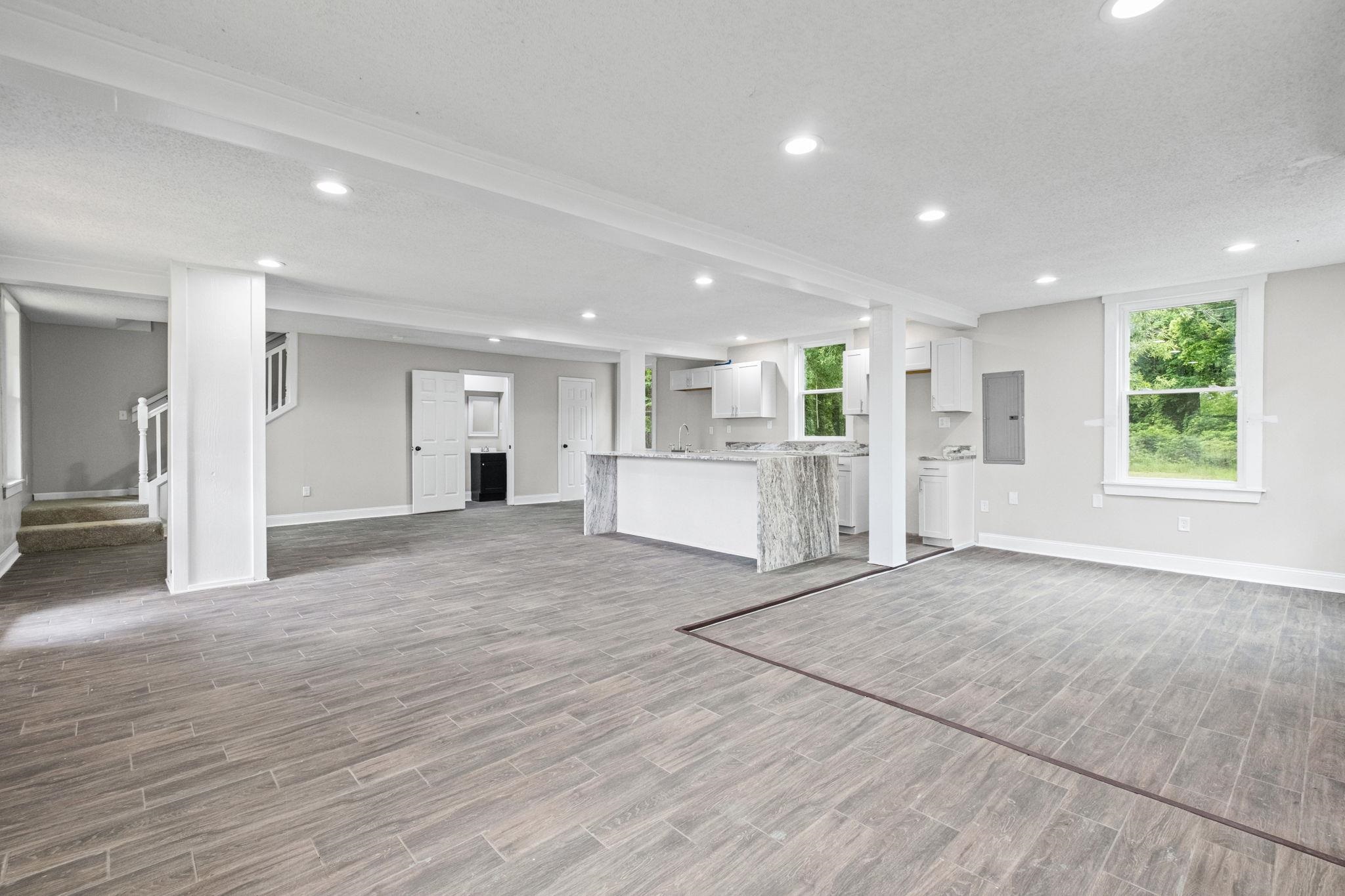 5843 Stewart Road Lakeland, TN 38002 - Photo 7 of 26 Spacious open-concept lower level featuring durable wood-look tile flooring, recessed lighting, and a modern kitchen area
