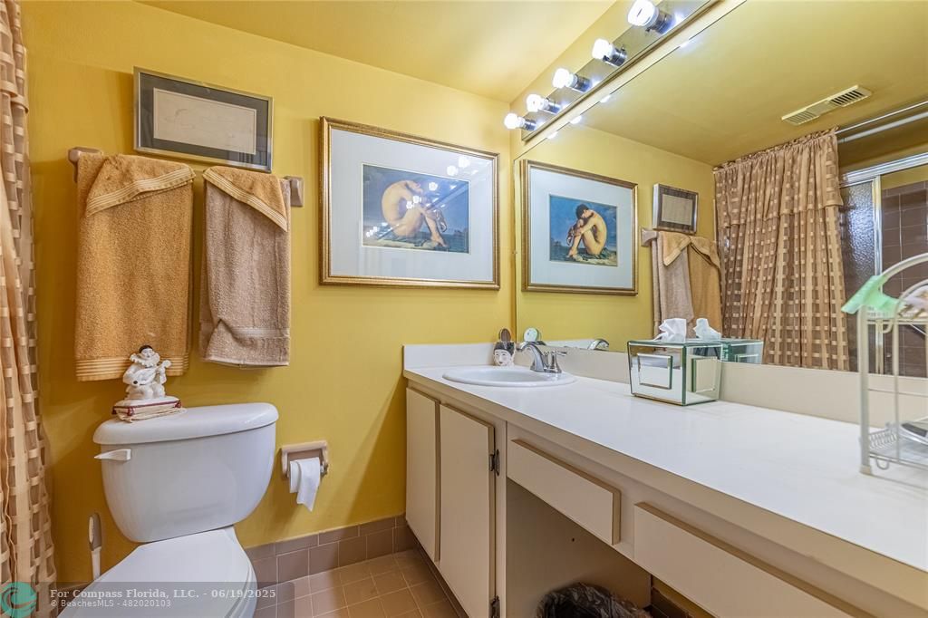 8305 Northwest 61st Street, Unit C215 Tamarac, FL 33321 - Photo 13 of 28 a bathroom with a toilet sink and mirror