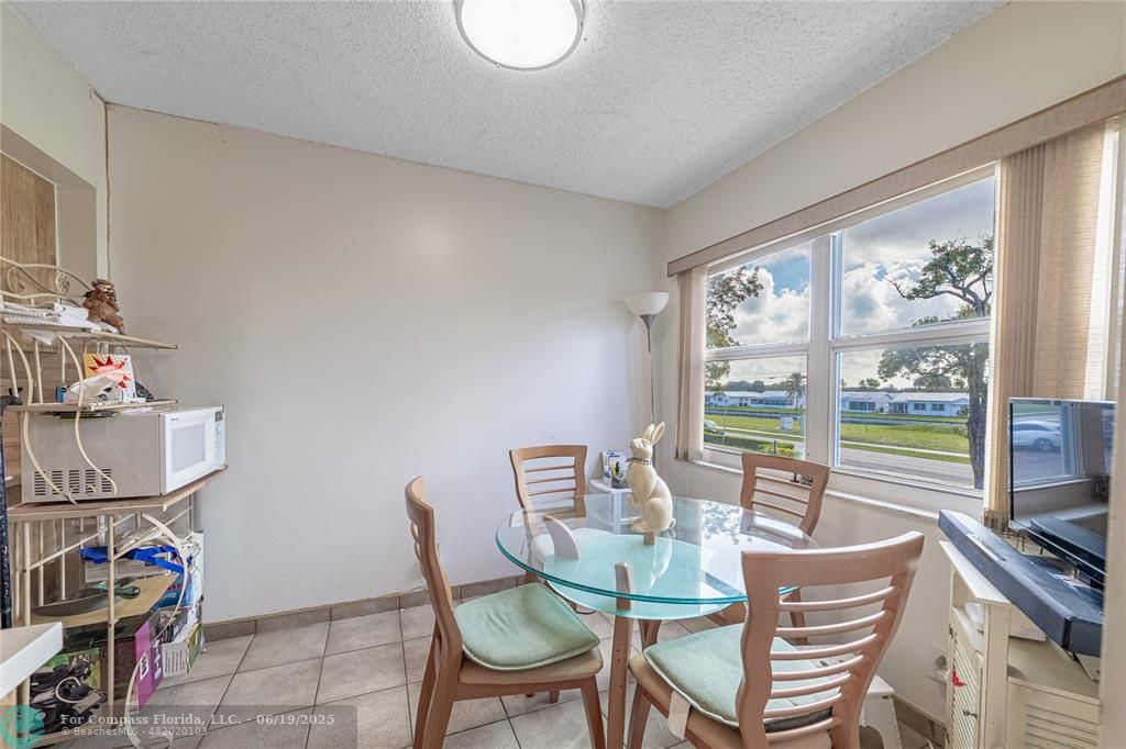 8305 Northwest 61st Street, Unit C215 Tamarac, FL 33321 - Photo 16 of 28 a dining room with furniture and a floor to ceiling window
