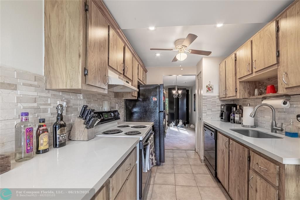 8305 Northwest 61st Street, Unit C215 Tamarac, FL 33321 - Photo 18 of 28 a kitchen with stainless steel appliances granite countertop a sink and cabinets