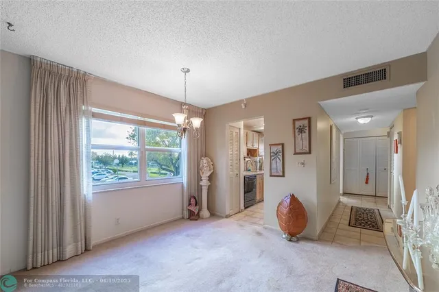 a living room with patio furniture and a floor to ceiling window