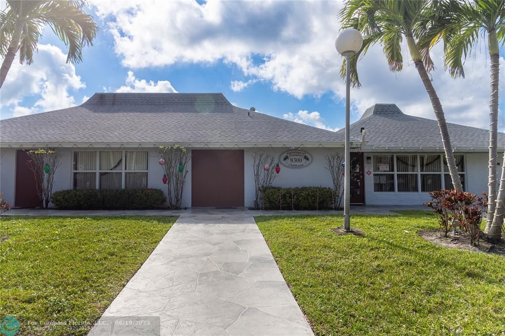 8305 Northwest 61st Street, Unit C215 Tamarac, FL 33321 - Photo 27 of 28 a front view of a house with a garden and patio