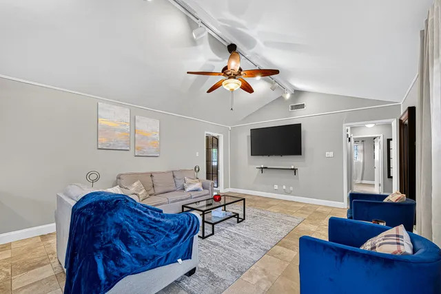 a living room with furniture a flat screen tv and wooden floor