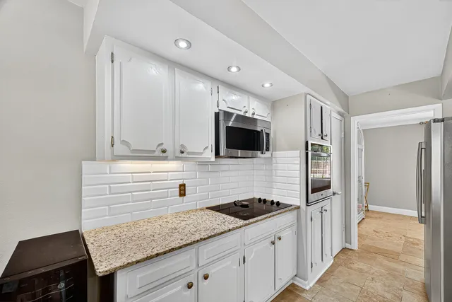 a kitchen with granite countertop a sink and stainless steel appliances