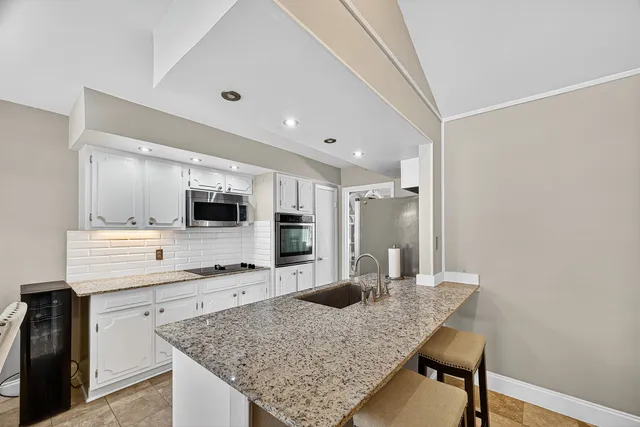 a kitchen with a counter top space a sink and appliances