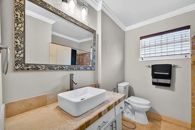 a bathroom with a toilet a sink and a mirror