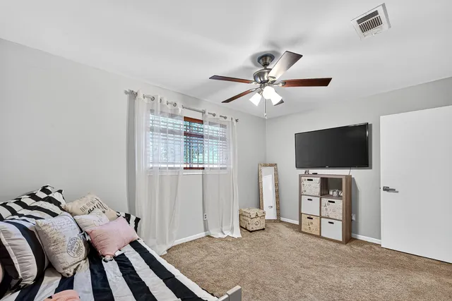 a bedroom with furniture and a flat screen tv
